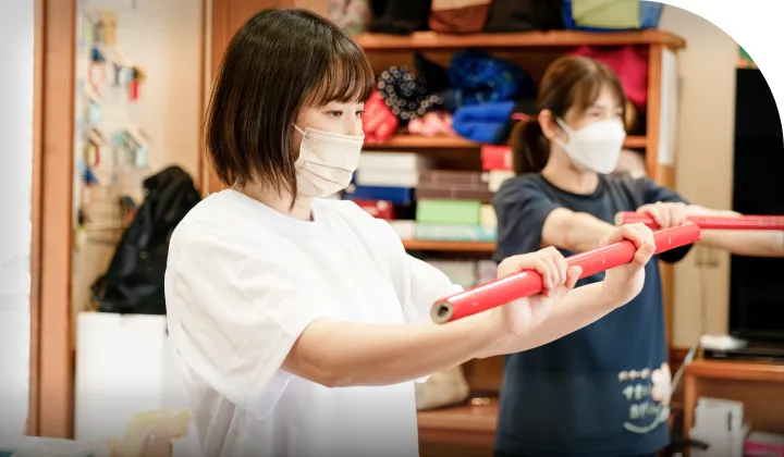 棒を使って体操をするスタッフ