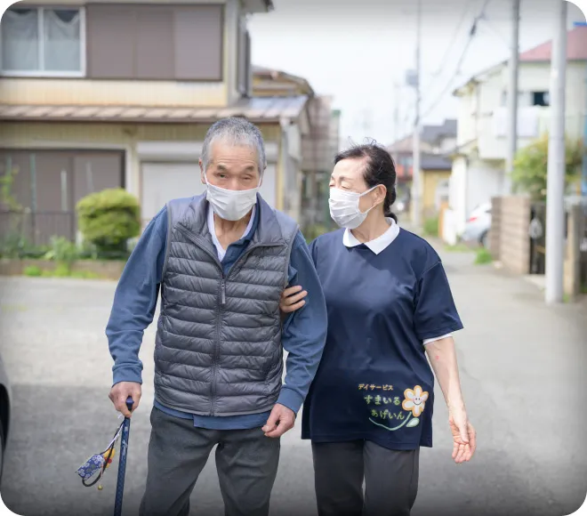 スタッフに付き添われて歩くご利用者様